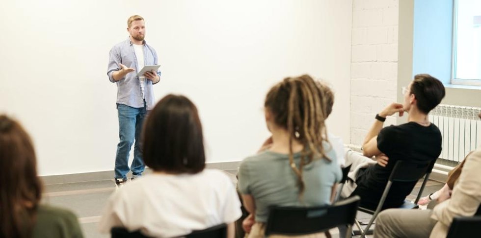 Alumnos atienden a las explicaciones de un profesor.
