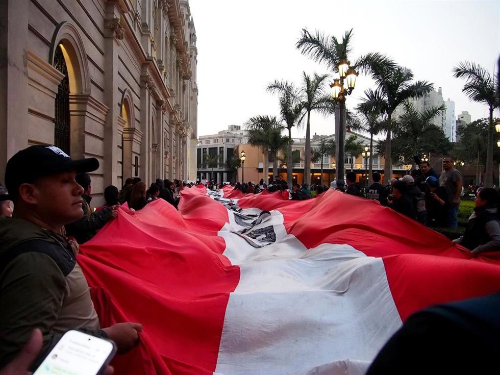 Manifestantes ondean la bandera de Perú en la capital del país