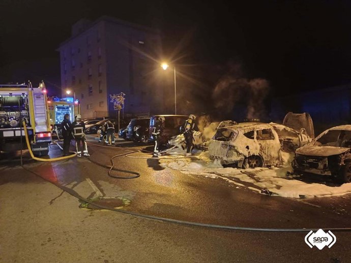 Los bomberos extinguen el fuego declarado en varios vehículos de madrugada en Avilés.