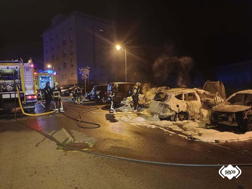 Los bomberos extinguen el fuego declarado en varios vehículos de madrugada en Avilés.