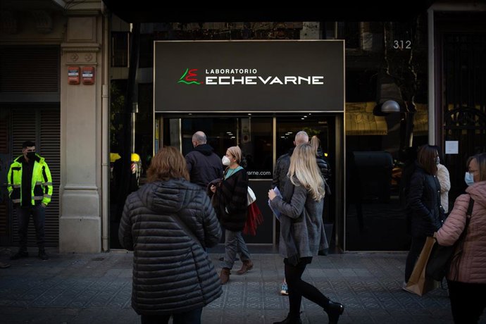 Archivo - Varias personas hacen cola para hacerse test y otras pruebas de covid, en el laboratorio Echevarne, a 20 de diciembre de 2021, en Barcelona, Cataluña (España)