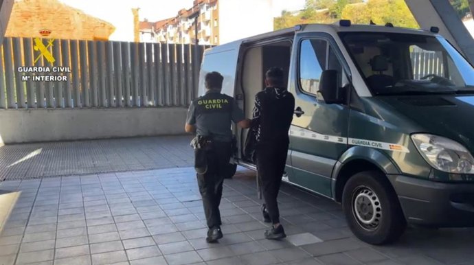 Un detenido trasladado a un furgón de la Guardia Civil