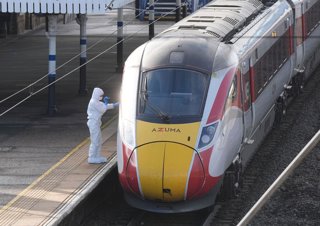 02 November 2025, United Kingdom, Huntingdon: A British forensic investigator stands on the platform beside a train at Huntingdon station in Cambridgeshire after several people were stabbed. Two people have been arrested after officers responded to the in