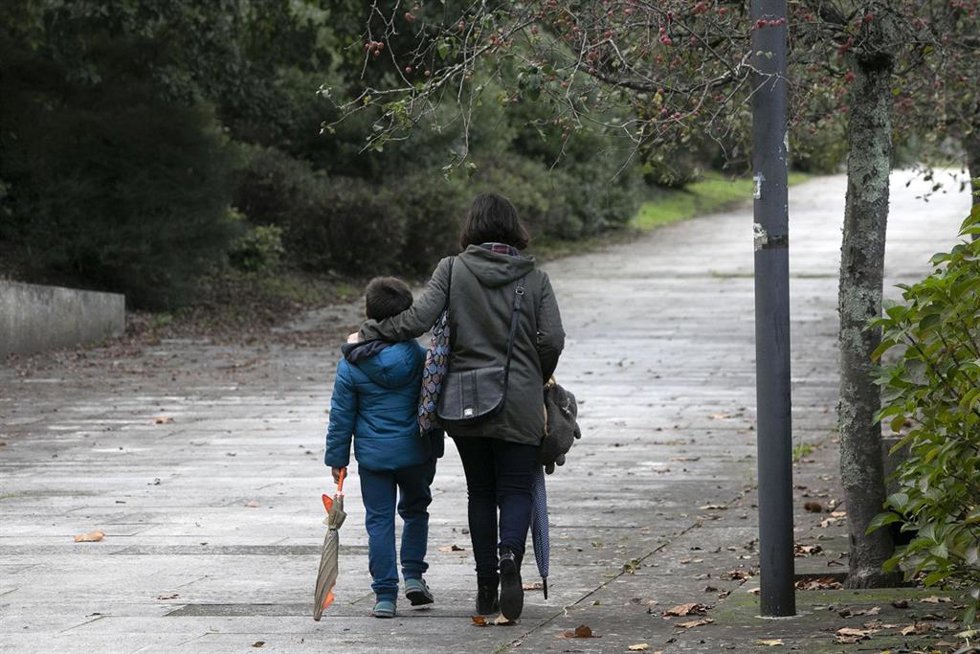 Archivo - Mujer pasea acompañada de un niño.
