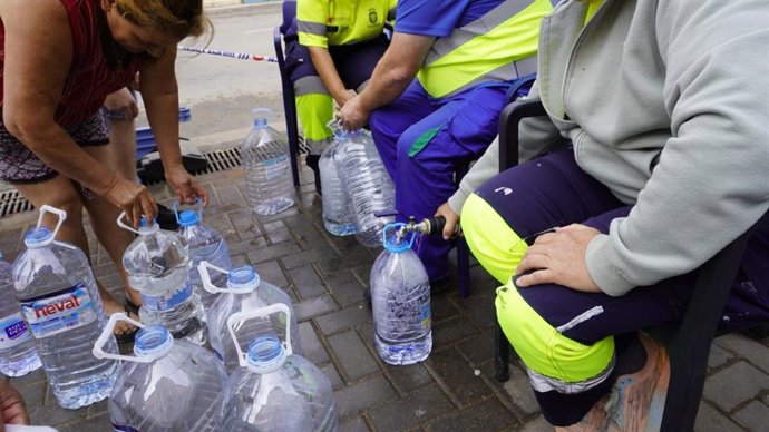 Vecinos rellenando garrafas de agua en las cubas móviles durante el corte de agua