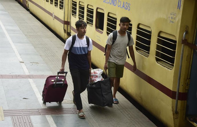 Archivo - Imagen de archivo de varios pasajeros subiéndose a un tren en India.