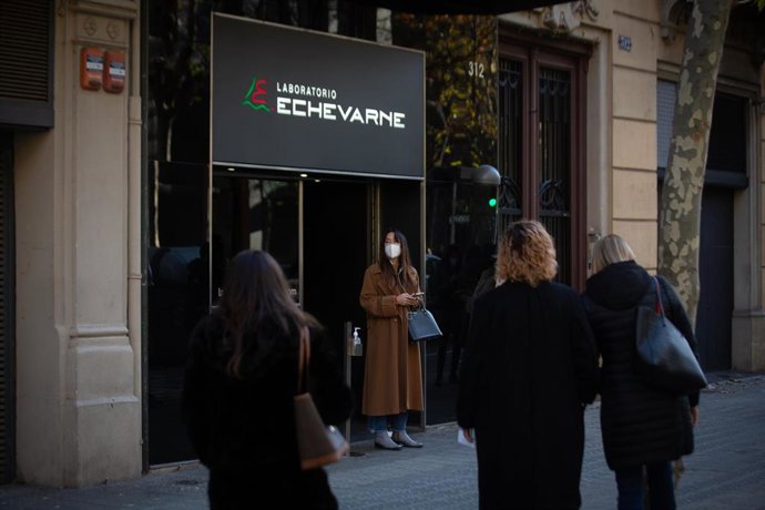 Archivo - Varias personas hacen cola para hacerse test y otras pruebas de covid, en el laboratorio Echevarne, en una imagen de archivo.