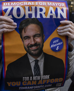 November 4, 2025, New York, New York, USA: A protester with the activist group Rise & Resist holds a campaign poster that reads DEMOCRAT FOR MAYOR ZOHRAN VOTE NOV 4 FOR A NEW YORK YOU CAN AFFORD' outside of Fox News Channel on Election Day as the highly w