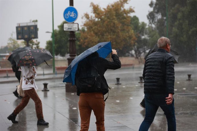 Imágenes de sevillanos refugiándose de la lluvia torrencial y el fuerte viento, que la capital hispalense ha sufrido en la jornada de hoy. A 29 de octubre de 2025, en Sevilla (Andalucía, España). 