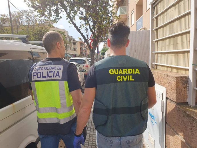 Un agente de la Guardia Civil y otro de la Policía Nacional, durante una de las redadas efectuadas en el marco de la operación.