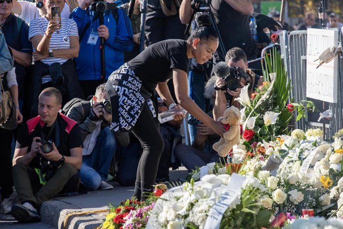Imagen de archivo de una mujer depositando flores en recuerdo de las víctimas del derrumbe de la estación de tren de Novi Sad.