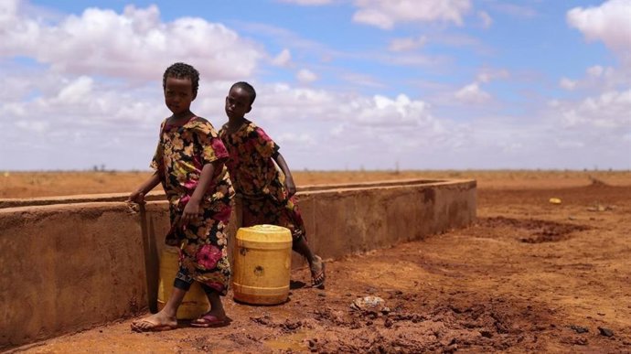 Archivo - Dos niños en punto de recogida de agua en Kenia.