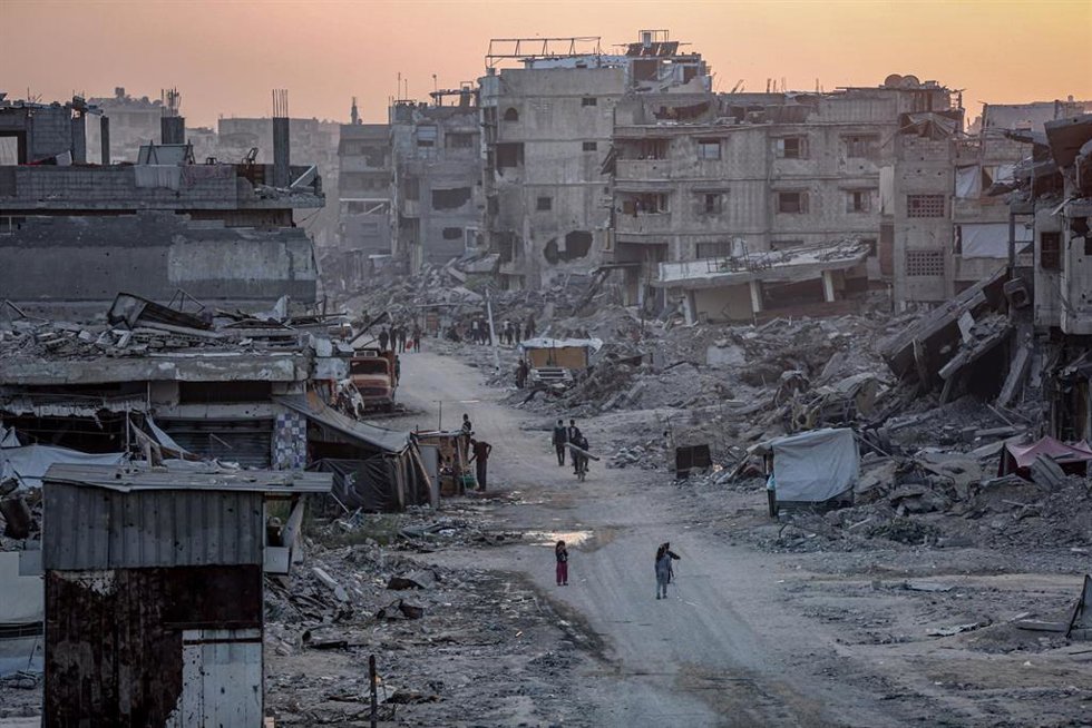 Palestinos caminando entre edificios destruidos por los ataques de Israel contra Shujaia, en el norte de la Franja de Gaza (archivo)