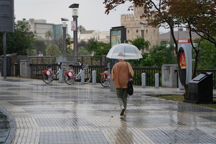 Archivo - Viandantes por las calles de Sevilla con paraguas abiertos, a 18 de mayo de 2023, en Sevilla, (Andalucía, España). La Agencia Estatal de Meteorología acierta y llueve sobre Sevilla. Esta medio día a comenzado a llover según lo previsto por la Ae