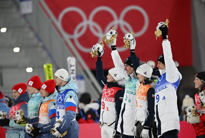 Archivo - 07 February 2022, China, Zhangjiakou: Second-placed team Russia (L) and winning team Slovenia celebrate on the podium after the end of the mixed team Ski Jumping event at the National Ski Jumping Center during Beijing 2022 Winter Olympic Games. 