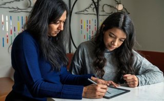 Dos mujeres revisando un texto en un lector Kindle