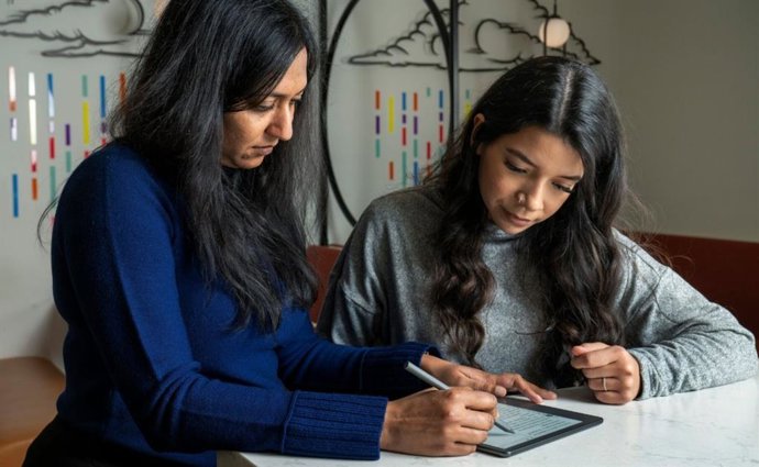 Dos mujeres revisando un texto en un lector Kindle