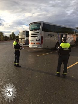 Archivo - Agentes de la Policía Local de Zaragoza inspeccionan varios autobuses de transporte escolar en imagen de archivo.
