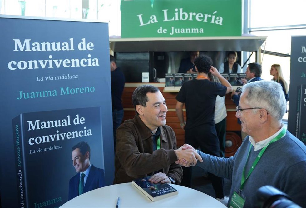 El presidente de la Junta y del PP-A, Juanma Moreno, estrecha este sábado la mano de un militante durante la firma de ejemplares de Manual de convivencia en el marco del XVII Congreso de este partido.