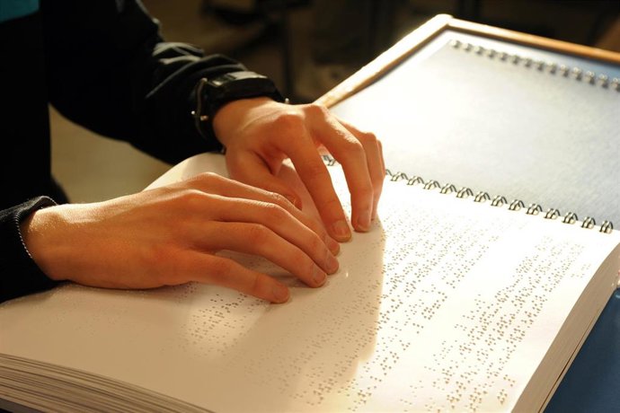 Archivo - Imagen de archivo de un joven en clase leyendo en braille