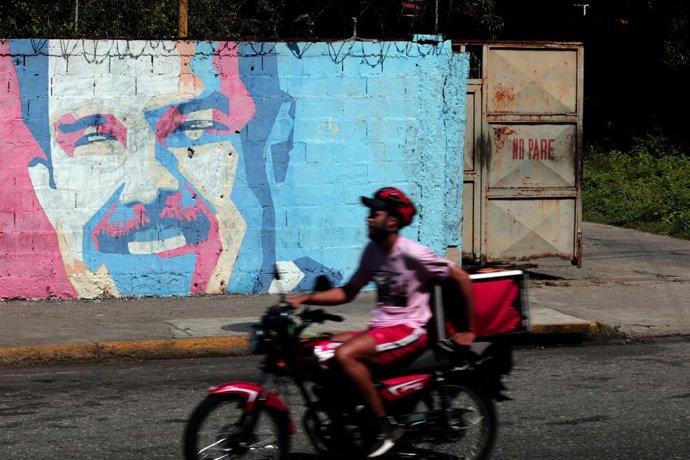 Archivo - Arquivo - 20 de agosto de 2025, Valencia, Carabobo, Venezuela: 20 de agosto de 2025.  Aman passa em sua motocicleta por grafites que retratam o presidente venezuelano Nicolas Maduro. Os Estados Unidos estão oferecendo uma recompensa de US$ 50 mi