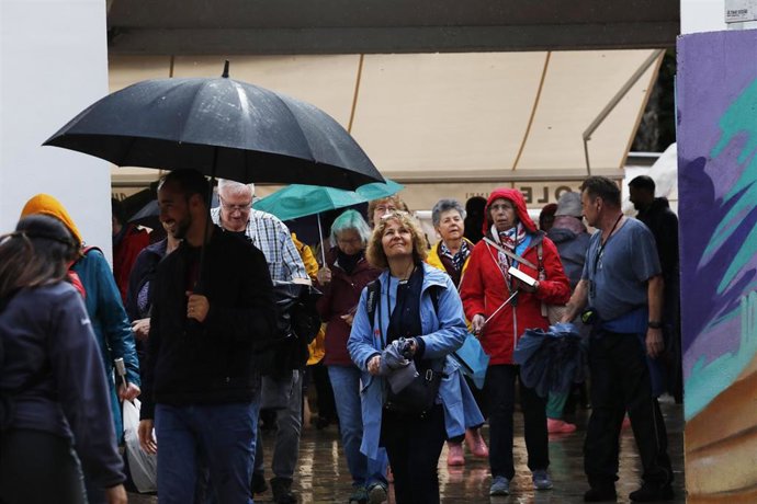 Archivo - Imagen de archivo de varias personas protegiéndose de la lluvia en Málaga, a 13 de marzo de 2025.