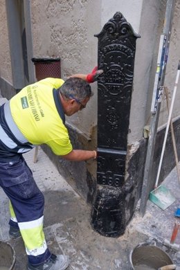 Operarios municipales del Ayuntamiento de Cádiz trabajando en la reposición de un guardacantón del centro de la ciudad