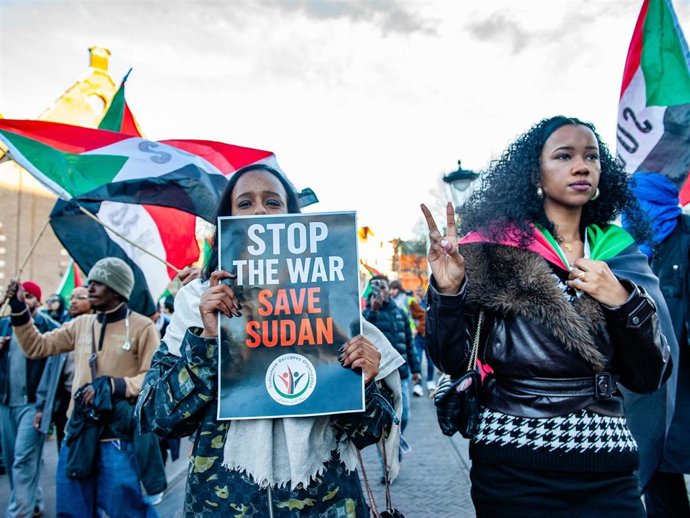 Una mujer sudanesa sostiene una pancarta contra la guerra en Sudán durante una manifestación en Utrecht, Países Bajos