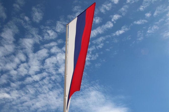 Archivo - Una bandera rusa ondea, vertical, en el cielo