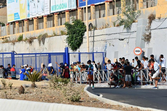 Archivo - Cientos de personas, la mayoría marroquíes, guardan cola en la oficina para tramitar los asilos situada en la frontera del Tarajal que separa Ceuta de Marruecos, a 3 de agosto de 2021, en Ceuta (España). 