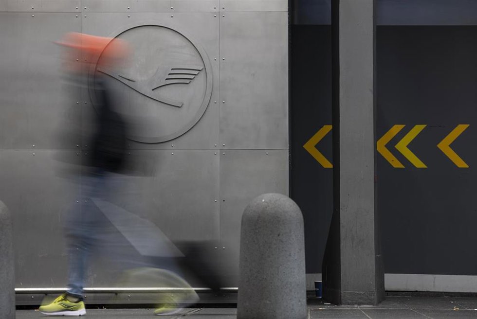 Archivo - 29 September 2025, Hesse, Frankfurt/Main: A man walks in front of a Lufthansa logo at Frankfurt Airport. Company sources have revealed that the Group intends to cut a fifth of its administrative jobs in the coming years.