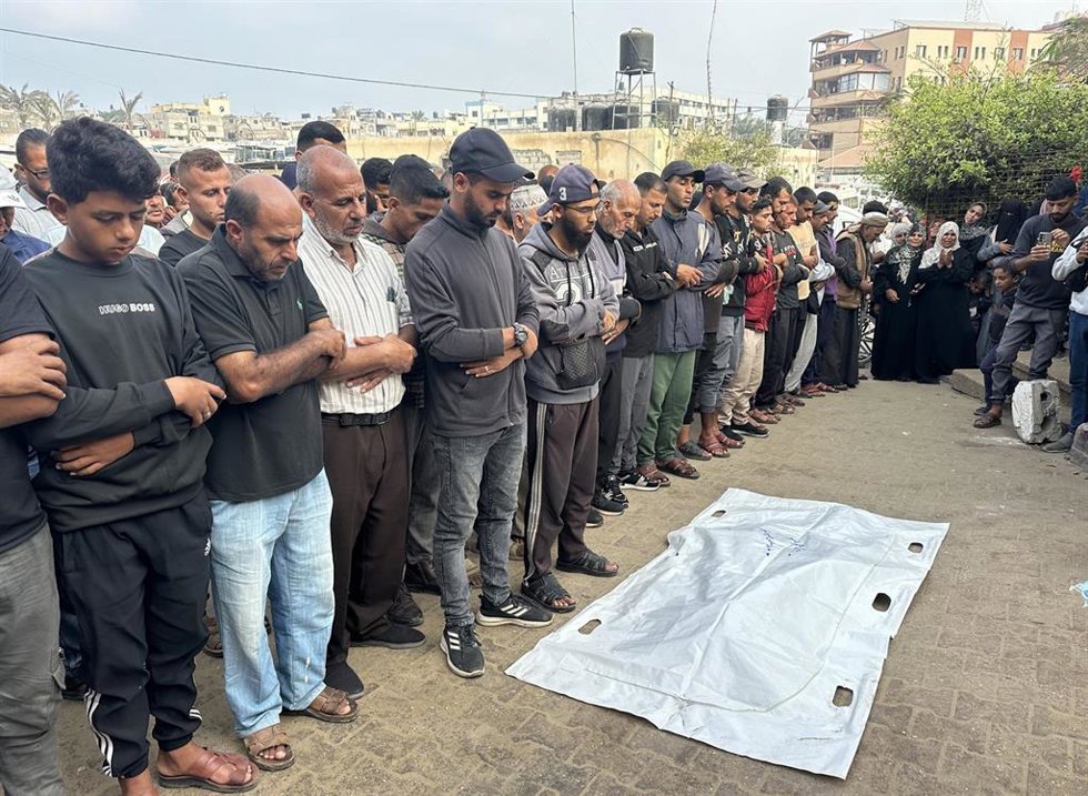 Palestinos junto al cadáver de un hombre muerto en un ataque de Israel contra Jan Yunis, en el sur de la Franja de Gaza, a pesar del alto el fuego que entró en vigor el 10 de octubre de 2025