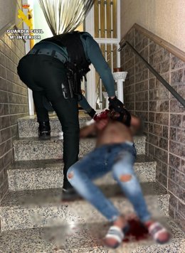 Un agente de la Guardia Civil auxilia al hombre herido en su vivienda de Matagorda, en El Ejido (Almería).