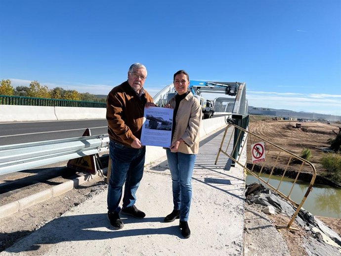 Francisco Jurado e Isabel Ambrosio ante el Puente de Hierro de Villa del Río, donde se están ejecutando trabajos.