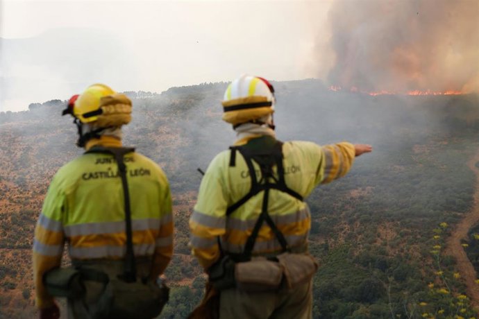 Archivo - Varios bomberos observan el incendio forestal, a 24 de agosto de 2025, en La Baña, Encinedo, La Cabrera, León, Castilla y León (España).