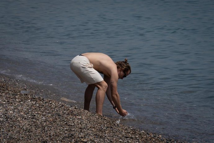Archivo - Un hombre se refresca en la playa de la Barceloneta