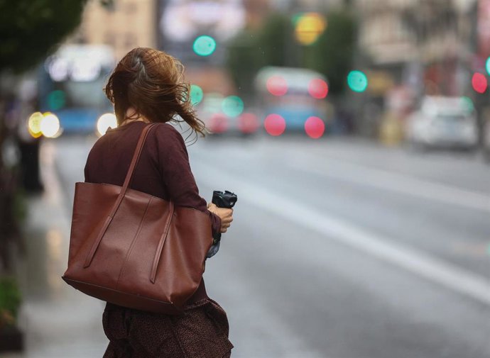 Archivo - Una mujer se despeina por el aire en la calle 
