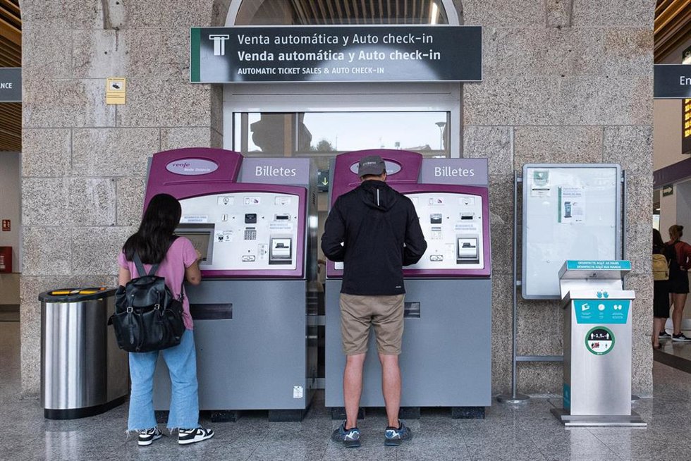 Archivo - Dos personas compran billetes en los cajeros de venta automática en la estación de trenes, a 24  de agosto de 2022, en Santiago de Compostela, A Coruña, Galicia, (España). Los usuarios de Renfe en Galicia pueden adquirir desde hoy los abonos g