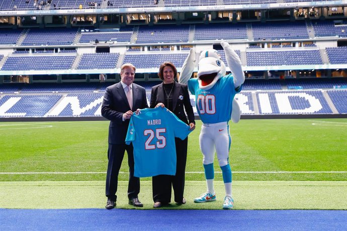 Archivo - Pri Shumate, directora de Marketing de los Miami Dolphins y Brett Gosper, director de la NFL en Europa y Asia-Pacífico, posan junto a la mascota de los Dolphins en el Santiago Bernabéu