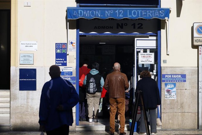 Archivo - Varias personas hacen cola para comprar décimos de la Lotería de Navidad.