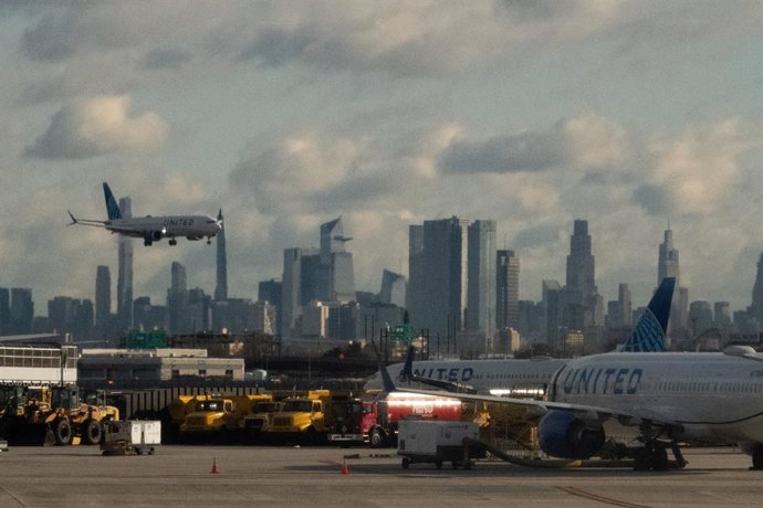 11 November 2025, US, Bonn: A United Airlines flight lands at Newark Liberty International Airport in Newark. The US House of Representatives is discussing an interim budget and thus a possible end to the partial government shutdown. Photo: Bryan Smith/ZU