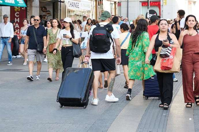 Archivo - Turistas con maletas por el centro de la ciudad