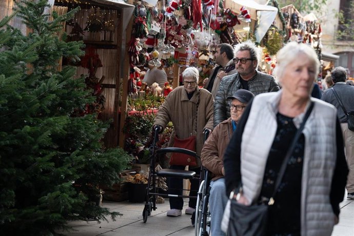 Archivo - (Foto De ARCHIVO) Varias Personas Pasean Entre Los Puestos Del Mercadillo Navideño