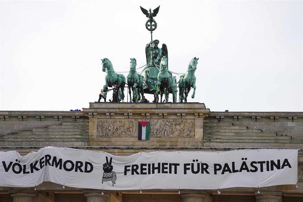 Activistas colocan una pancarta en la Puerta de Brandenburgo de Berlín, Alemania para protestar contra la ofensiva de Israel contra la Franja de Gaza