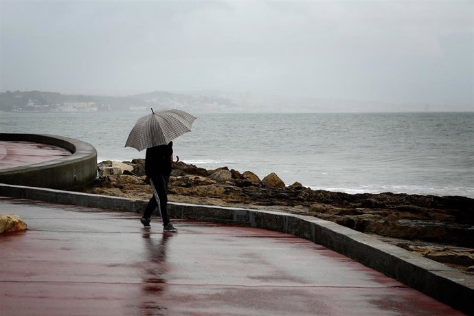 Archivo - Una persona con un paraguas bajo la lluvia en Lisboa, Portugal