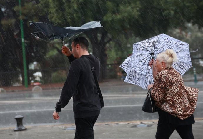 Imágenes de sevillanos refugiándose de la lluvia torrencial y el fuerte viento en imagen de archivo.