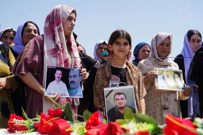 Archivo - Arquivo - 1º de agosto de 2024, Zakho, Iraque: Mulheres iraquianas yazidis seguram fotos de suas vítimas e parentes desaparecidos durante uma cerimônia no campo de Chamishko, na região do Curdistão do Iraque, marcando o 10º aniversário do genocí