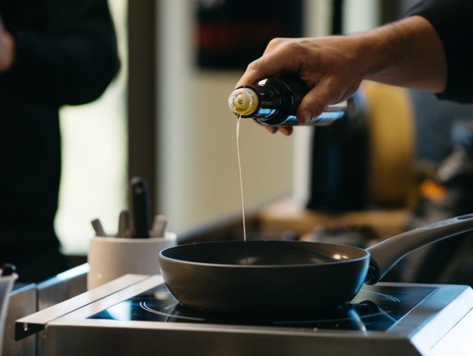 Archivo - Un cocinero usando aceite.