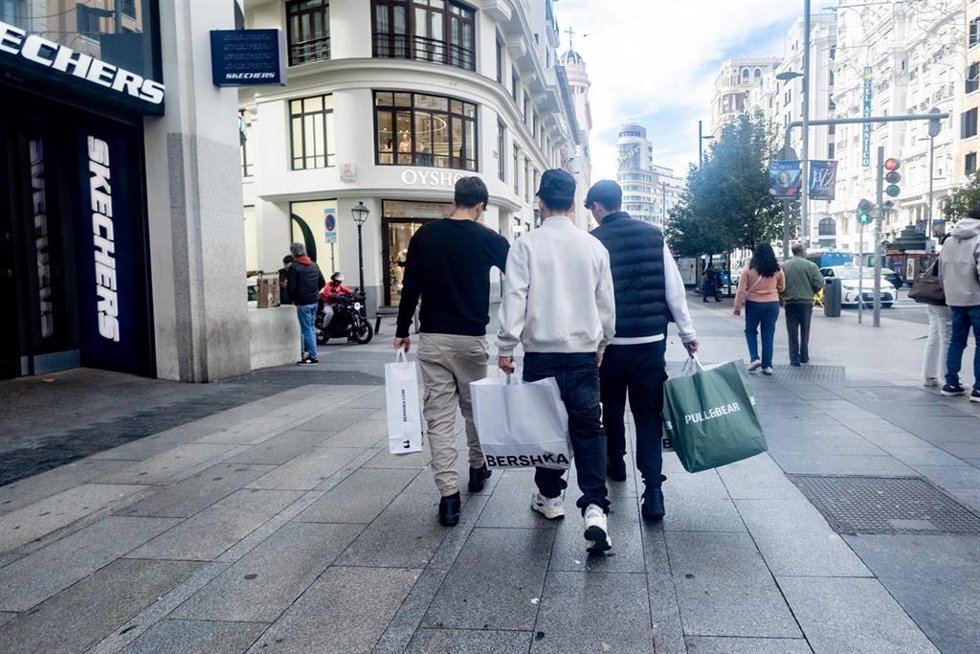 Archivo - Varias personas con una bolsas de compras