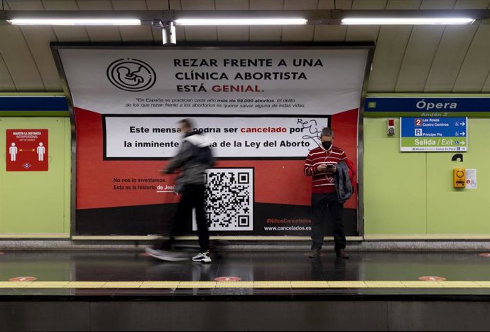 Archivo - Varias personas al lado de un cartel para rezar contra el aborto en el andén de la estación de Ópera, a 24 de enero de 2022, en Madrid (España). La Asociación Católica de Propagandistas (ACdP) ha colocado mensajes publicitarios en los que se lee
